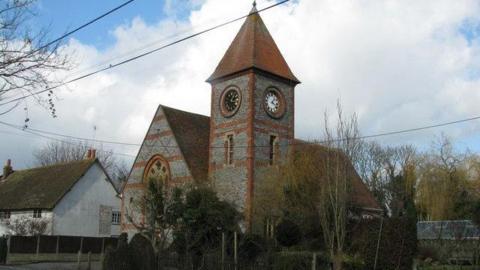 Stewart Village Hall in Brightwell-cum-Sotwell, Oxfordshire. It is a large grey and red building with a clocktower.