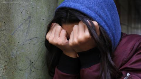 A woman covering her face with her hands