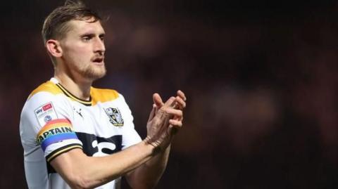 Close up of Port Vale captain Nathan Smith clapping the crowd