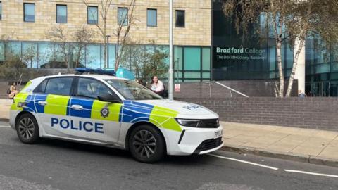 Police car parked at the scene outside Bradford College on Great Horton Road.