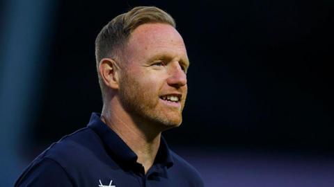 Shrewsbury Town head coach Gavin Cowan looks to the right with a smile during a pre-season game