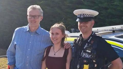 Evie (middle) was escorted to her prom by PC Burke (right) and her father (left)
