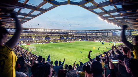 A CGI image of fans in the ground at the Triangle celebrating with many fans cheering and blue and yellow tape flying around in the air.