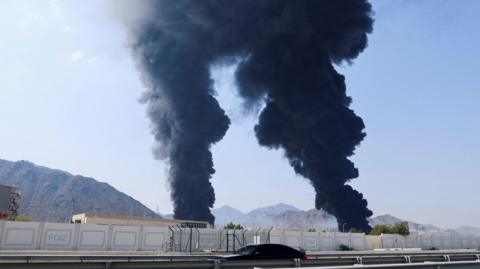 Smoke rises in the Fujairah oil industry zone, caused by debris after interception of a drone by air defenses