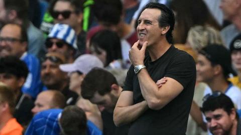 Unai Emery with his hand on his chin looking pensive on the touchline at Brighton