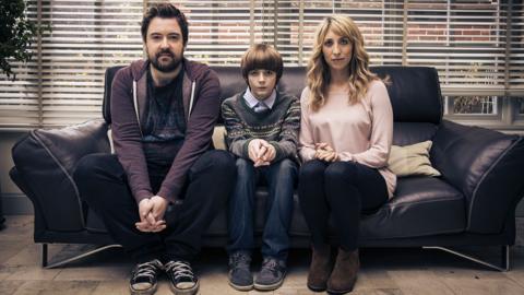 Elliot Speller-Gillott as
Errol Nick Helm as
Andy Daisy Haggard as
Sam Scene of them sitting together on a leather sofa. Posing for a photograph.