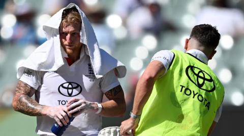 Ben Stokes with a towel over his head during a drinks break in Adelaide