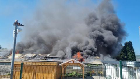 Fire smoke in the sky coming out of building on fire