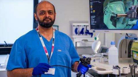 A doctor holding medical equipment in a hospital