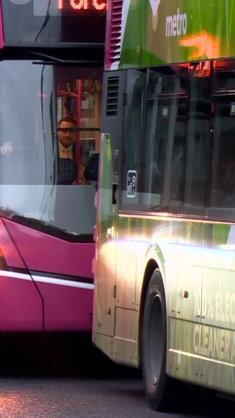 Two pink metro buses parked up back to back 