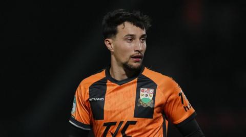 Ryan Galvin playing for Barnet in their orange and black kit