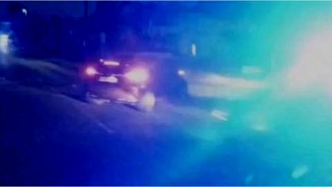 Still from video showing police car hitting another car