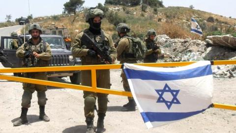 File photo showing Israeli soldiers guarding an entrance to the site of the evacuated settlement of ˿sh (27 May 2022)