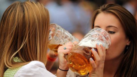 Young women enjoy drinking beer out of 1-liter-mugs of beer during the opening weekend of the 2019 Oktoberfest