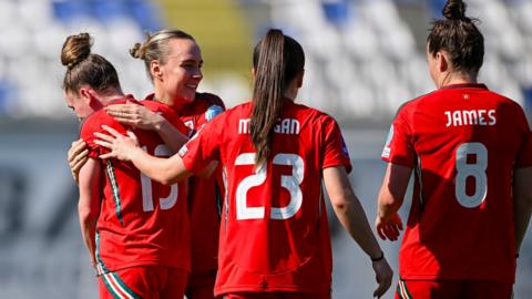 Wales players celebratw with Rachel Rowe