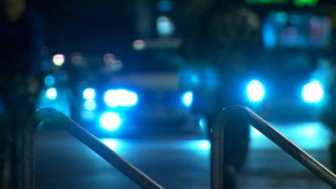 Blue lights from police cars lighting up a street