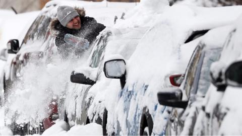 Man clears snow off car in Moscow