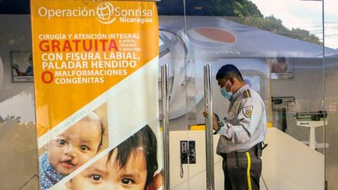 A security guard stands at the office of NGO Operacion Sonrisa one of the 25 NGOS declarated Ilegal by Nicaraguan Parliament in Managua, on March 17, 2022.