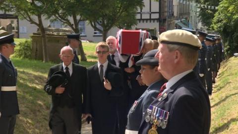 Servicemen line the church path as Mr Burrows' coffin is carried to the church