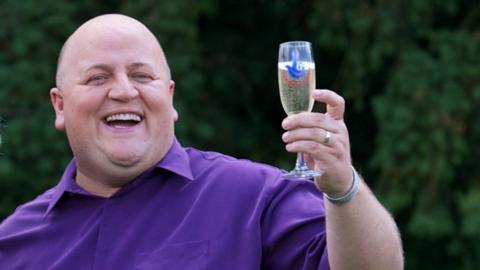 Adrian Bayford celebrates his lottery win