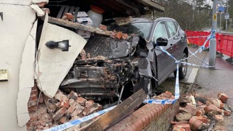 Car in the side of a pub