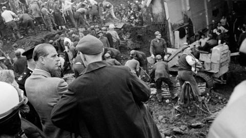 The Duke meets rescue workers and miners in Aberfan as people search through the rubble