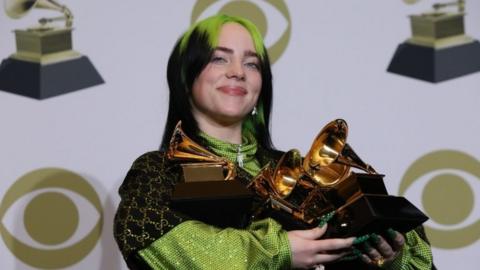 Billie Eilish holding her Grammys