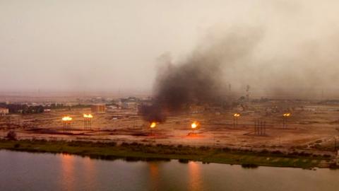 Flares at Iraqi oil field are shown burning gas next to villages