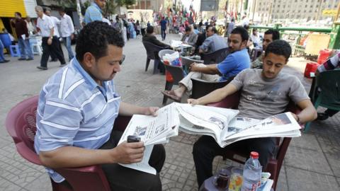 Reading papers at a Cairo cafe