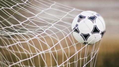 Football in the back of the goal net