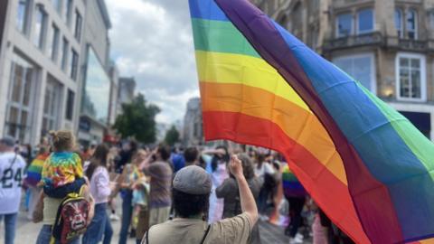 Man holding a rainbow flag