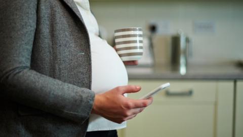 Pregnant woman holding a phone