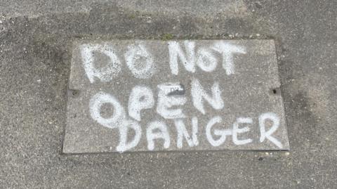 A warning on a manhole cover