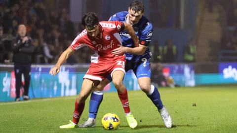 Crawley Town's Josh Flint battles with Gillingham's Josh Andrews