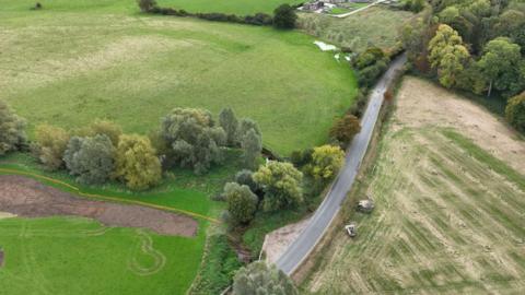 A bird's eye view of the new wetland. It is very green with grass and trees everywhere  