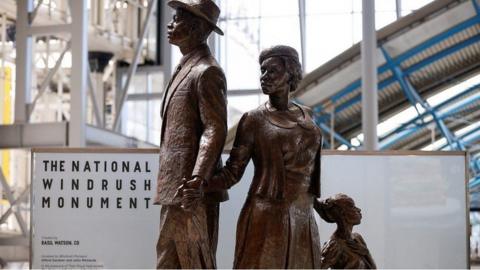 A statue of a man, woman and child commemorating the Windrush generation