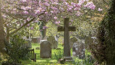 Cross in churchyard in spring