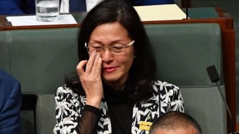 Gladys Liu wipes away a tear while sitting in Australia's parliament