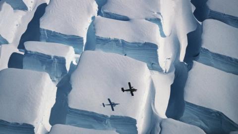 Plane and its shadow with ice below