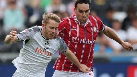 Ollie Cooper (left) of Swansea City is challenged by Matthew James of Bristol City