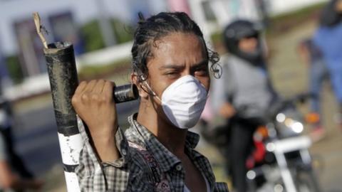 A student holds a makeshift mortar during clashes with riot police in front of the Engineering University, within a protest against the government"s reforms in the Institute of Social Security (INSS) in Managua on April 20, 2018.