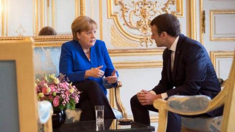 German Chancellor Angela Merkel and the French President Emmanuel Macron speak at the beginning of the Franco-German Council of Ministers at the Elysee Palace