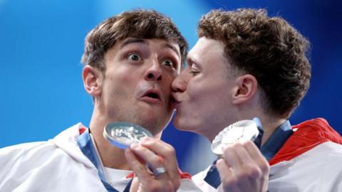 Noah Williams kisses Tom Daley after collecting their silver medals