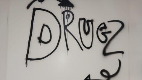 A white wall with black graffiti spelling out 'Drugz'