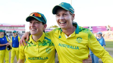 Megan Schutt (L) and Meg Lanning (R) with arms round one another after winning the Commonwealth Games final v India