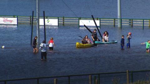 Children used kayaks to play on a flooded sports field in County Tyrone at the weekend as heavy rain turned Drumquinn Gaelic Athletic Association's ground into a lake.