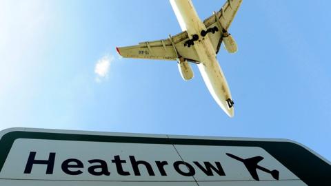 File image showing a plane flying above a Heathrow Airport sign