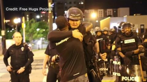 Ken Nwadike hugs a police officer