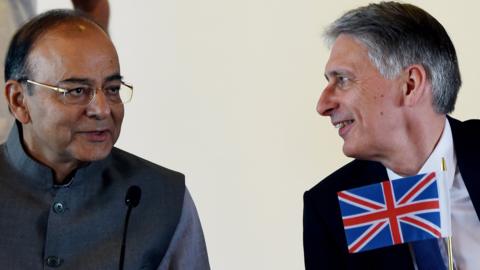 Indian Finance Minister Arun Jaitley (L) and British Chancellor Philip Hammond talk during a meeting in New Delhi