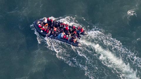 This aerial picture taken on September 16, 2023, from a police aircraft belonging to the French Police Aux Frontieres (PAF) shows migrants onboard of a dinghy used for smuggling as they attempt to cross the English Channel to Britain from a beach at Le Touquet, northern France